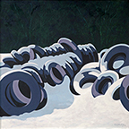 piles of snow covered tires lying in a field of snowwith dark trees in the background